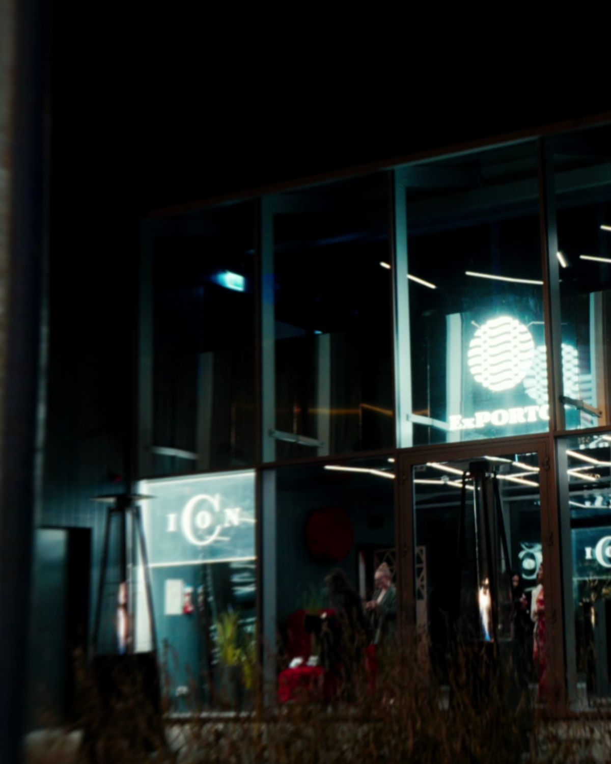 The venue's glass front, lit at night